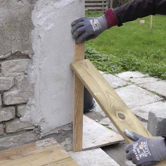 Ødelagt hjørne på pusset murvegg: Sett et bord på den ene siden av hjørnet Ødelagt hjørne på pusset murvegg: Sett et bord på den ene siden av hjørnet